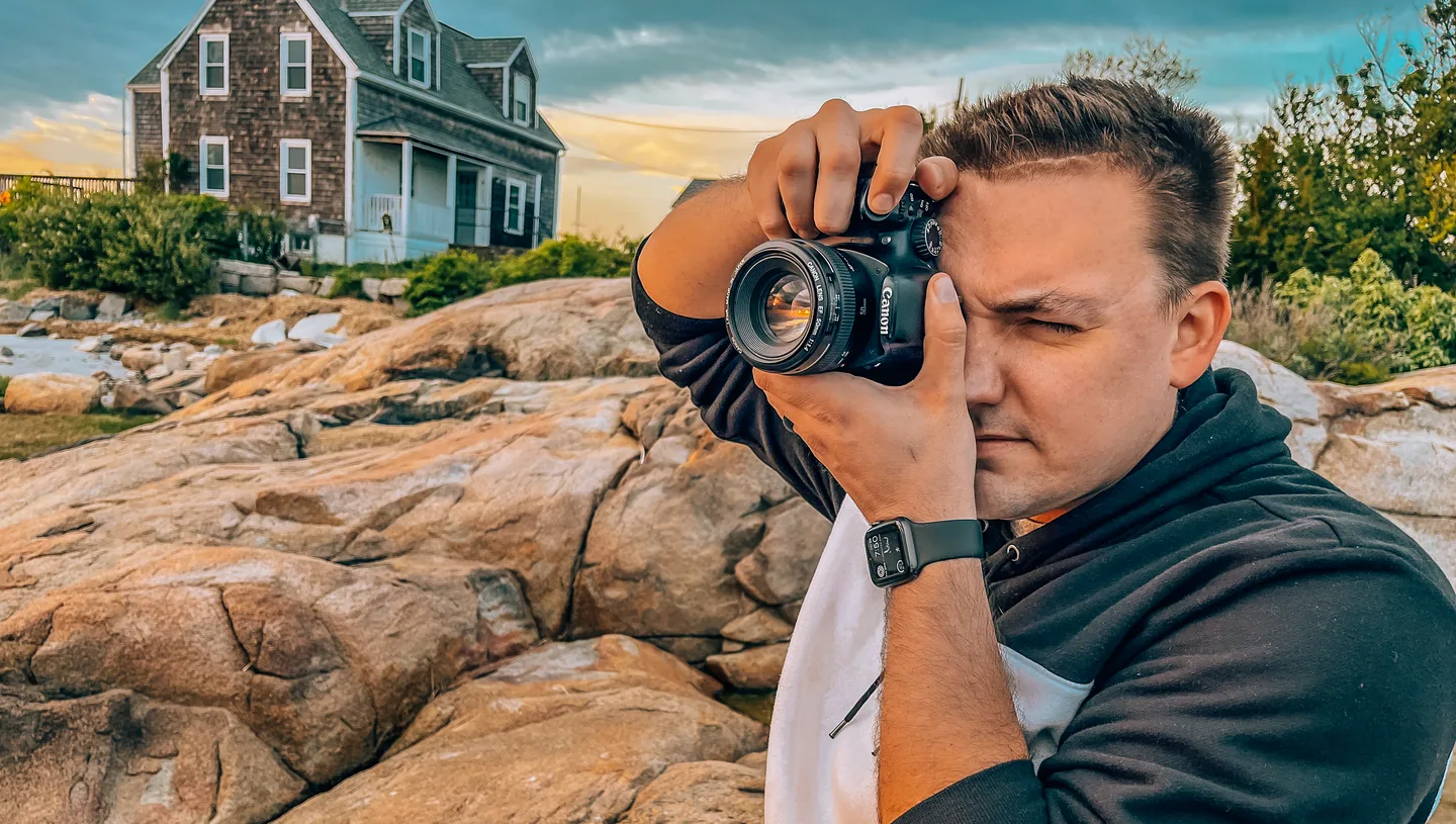 Peter Desrosier taking a photo of a sunset on a coastline.
